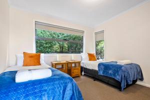 a bedroom with two beds and a window at Ocean View Cottages in Dover, Far South Tasmania in Dover