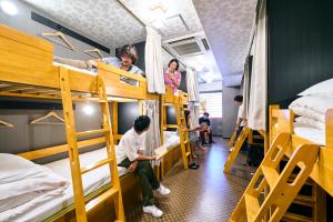 eine Gruppe von Personen in einem Schlafsaal mit Etagenbetten in der Unterkunft COGO TENNOJI in Osaka