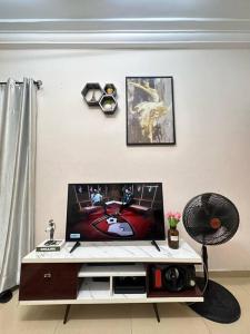 sala de estar con TV de pantalla plana sobre una mesa en Quick Apartments, en Cotonou