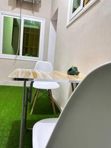 a table and chairs in a room with green grass at Quick Apartments in Cotonou