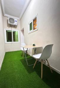 a room with a table and chairs and green carpet at Quick Apartments in Cotonou