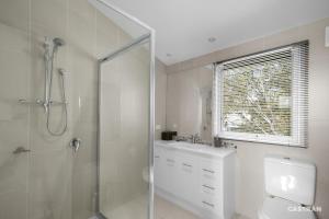 a bathroom with a shower and a toilet and a sink at Mayfair in Dinner Plain