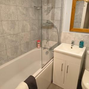 een badkamer met een douche, een bad en een wastafel bij Peaceful 3 Bedroom House wFree Parking Nature in Falmer