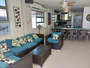 sala de estar con sofás azules y cocina en Cabañas Privadas en Playas del Francés con Piscina, en San Silvestre