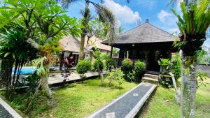a house with a garden and a road in front of it at Dong Loka Guesthouse Bali in Payangan