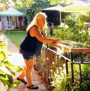 a woman standing next to a fence in a garden at Casa Pato in Mariano J. Haedo