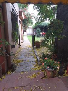 a walkway with pots of flowers and a fence at Casa Pato in Mariano J. Haedo