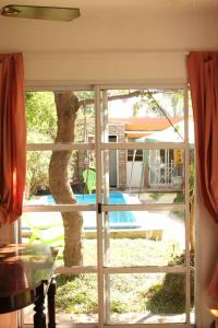 Blick auf einen Baum durch eine Glasschiebetür in der Unterkunft Casa Pato in Mariano J. Haedo