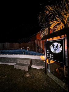 un panneau avec deux oiseaux assis sur un banc la nuit dans l'établissement 源和居旅宿, à Île Lamay