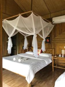 un dormitorio con una cama con dosel en Eco Homestay Mai Chau - Venuestay, en Mai Chau