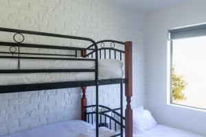 two bunk beds in a room with a brick wall at Bay Properties Beach Street in Yamba