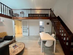 un salon avec un escalier et une table dans l'établissement Le 46 Magenta - Grand Duplex en hypercentre, à Poitiers