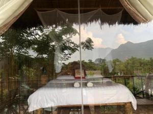 1 cama en una tienda de campaña con vistas a un árbol en Eco Homestay Mai Chau - Venuestay, en Mai Chau