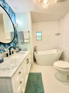a bathroom with a tub and a toilet and a sink at Tropical Oasis near beach in Naples