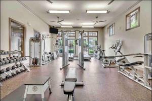 a gym with several treadmills and machines at Stylish-homes in Fort Worth