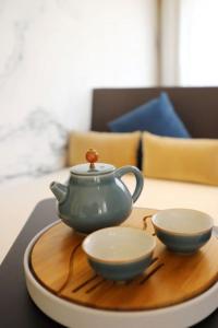 廣州的住宿－广州永庆坊瞻云精选酒店，茶壶和桌子上的盘子上的两个碗