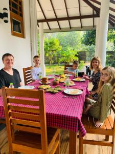 een groep mensen die rond een tafel zitten bij Riverview Cabana Tissamaharama in Tissamaharama