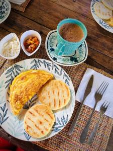 uma mesa com um prato de pão e uma chávena de café em CASA RAÍZ RÍO ANCHO em Mingueo