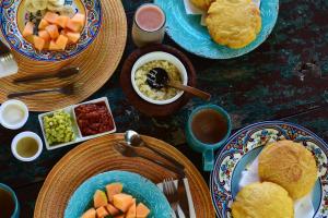 einen Tisch mit Teller mit Lebensmitteln und Schüsseln mit Lebensmitteln in der Unterkunft CASA RAÍZ RÍO ANCHO in Mingueo