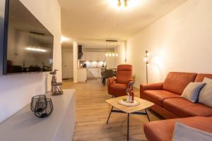een woonkamer met een bank en een tafel bij Dorumer Sielhuus 7 - Ferienwohnung mit Terrasse und Sauna in Dorum