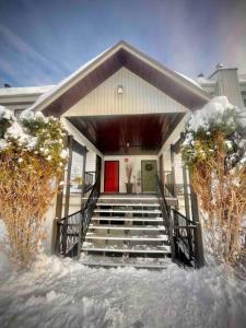 a house with a red door and stairs in the snow at Mountain Edge in Kimberley