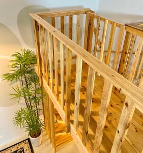 a wooden staircase in a room with plants at Hotel Little Swiss House in Motobu
