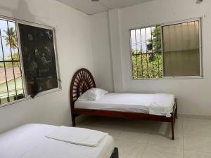 two beds in a room with two windows at Hermoso apartamento amoblado in Mompós