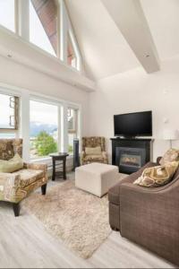 sala de estar con sofá y chimenea en Penthouse Lake Home - 3BR w/Amazing View & Deck!, en Harrison Hot Springs