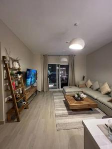 un soggiorno con divano e tavolo di 2 bedroom apartment Wabi Sabi in Yas a Abu Dhabi