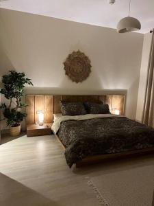 a bedroom with a large bed with two lights on the wall at 2 bedroom apartment Wabi Sabi in Yas in Abu Dhabi