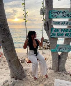 Freedom Beach Club في بارو: امرأة تجلس على مرجيحة على الشاطئ