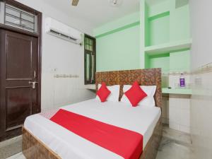 a bedroom with a large bed with red pillows at OYO Flagship Hotel Green Light in New Delhi