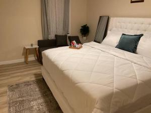 ein großes weißes Bett in einem Zimmer mit einer Couch in der Unterkunft Stylishly designed basement. in Lawrenceville