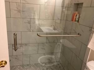 eine Dusche mit Glastür und Toilette in der Unterkunft Stylishly designed basement. in Lawrenceville + 31 Fotos