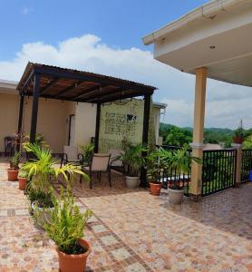 eine Terrasse mit Topfpflanzen und einem Pavillon in der Unterkunft Casa Victoria in San Benito