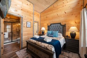 a bedroom with a bed in a log cabin at NEW/KING Bed/GAME room/HOT TUB/Central location in Sevierville