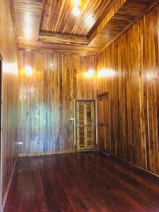 an empty room with wooden walls and wood floors at Baan Sangchan in Ko Kood