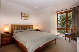 a bedroom with a large bed and a window at Heidelburg 3 of 6 Banjo Patterson Crescent in Jindabyne