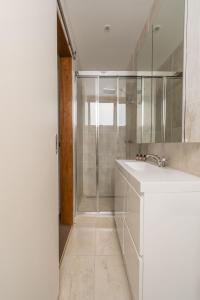 La salle de bains blanche est pourvue d'un lavabo et d'une douche. dans l'établissement Heidelburg 3 of 6 Banjo Patterson Crescent, à Jindabyne