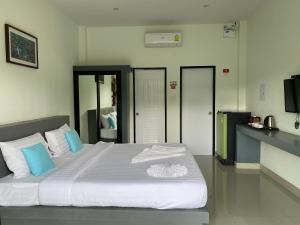 una camera da letto con un grande letto bianco con cuscini blu di Infinite Resort and Cafe a Krabi town