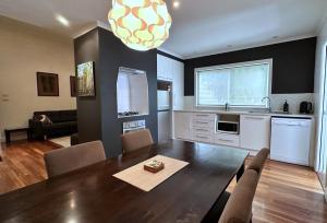 a living room with a dining room table and a kitchen at Townhouse 3 in Broken Hill