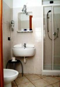 uma casa de banho com um lavatório e um chuveiro em Hotel Acquario em Gênova