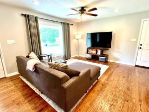 a living room with a couch and a flat screen tv at Newly Renovated- King Suite, near WakeMed & Food in Raleigh