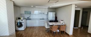 a kitchen with a table and chairs and a washer at Mud Beach Hotel in Boryeong