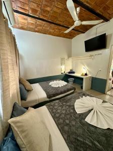um quarto com 2 camas e uma ventoinha de tecto em Bungalows Las Glorias em Rincón de Guayabitos