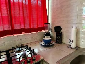 a kitchen with a stove and a red curtain at Bungalows Las Glorias in Rincon de Guayabitos