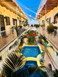 an indoor swimming pool in a building with palm trees at Bungalows Las Glorias in Rincon de Guayabitos +25 photos