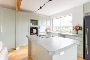a kitchen with white cabinets and a white counter top at NEW! Funky 2BR Chermside Escape in Brisbane