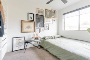 a bedroom with a bed and a table and a window at NEW! Funky 2BR Chermside Escape in Brisbane