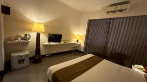 Habitación de hotel con cama y escritorio en Bali World Hotel, en Bandung